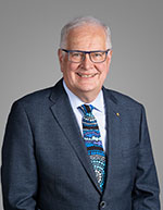 Head shot of Professor Samuel Berkovic in a dark blue suit with colourful blue tie