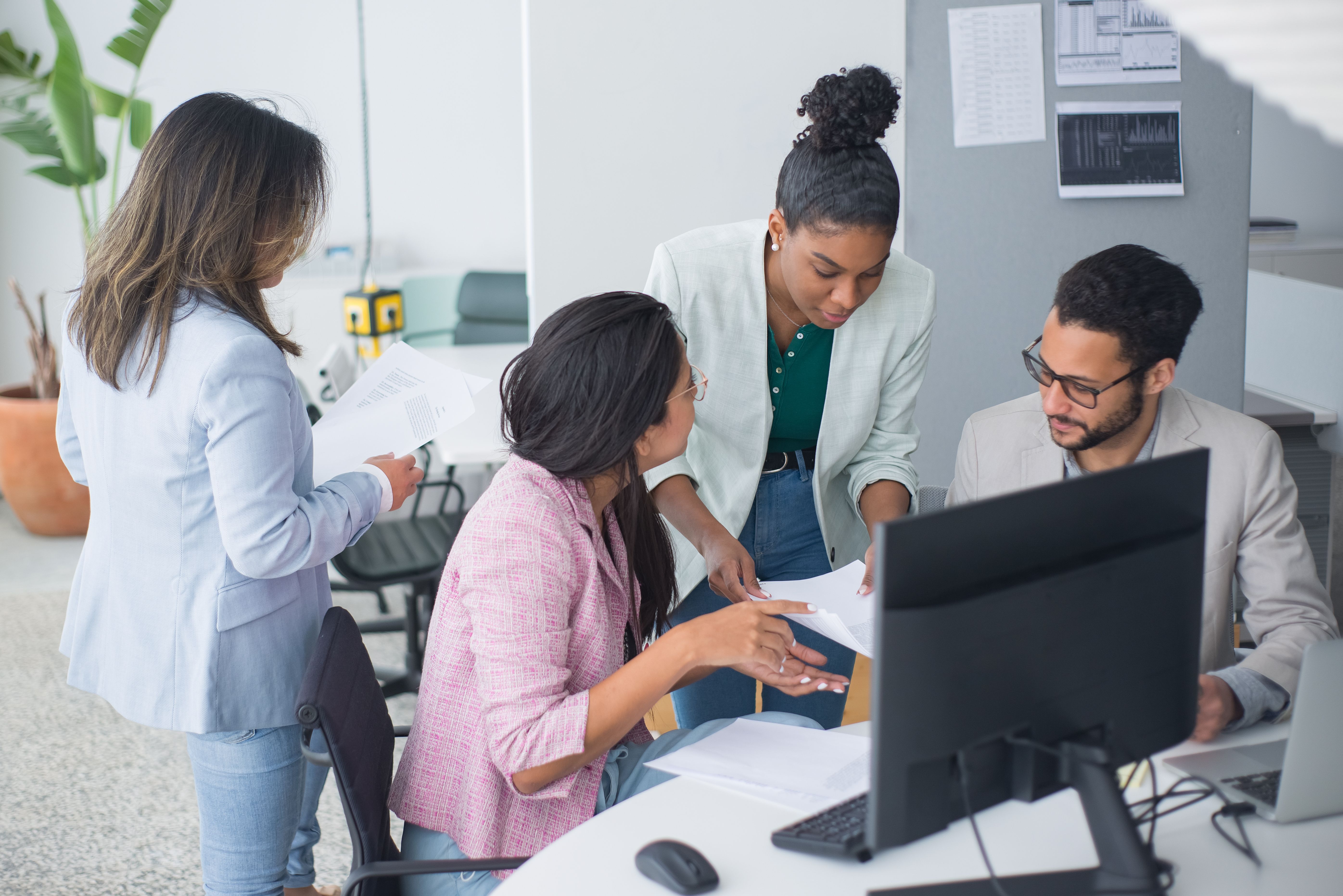 stock image of 4 coworkers in front of a computer