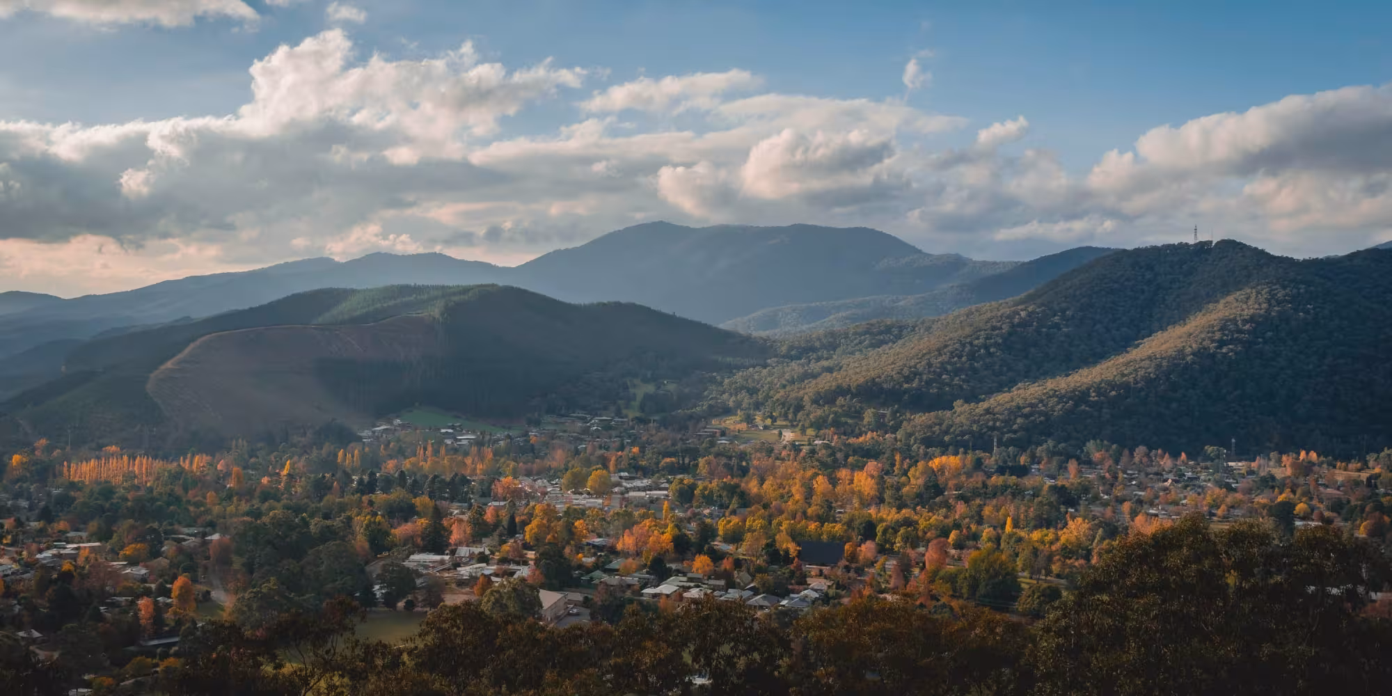 Drone image of Australian country town in a valley surrounded by trees