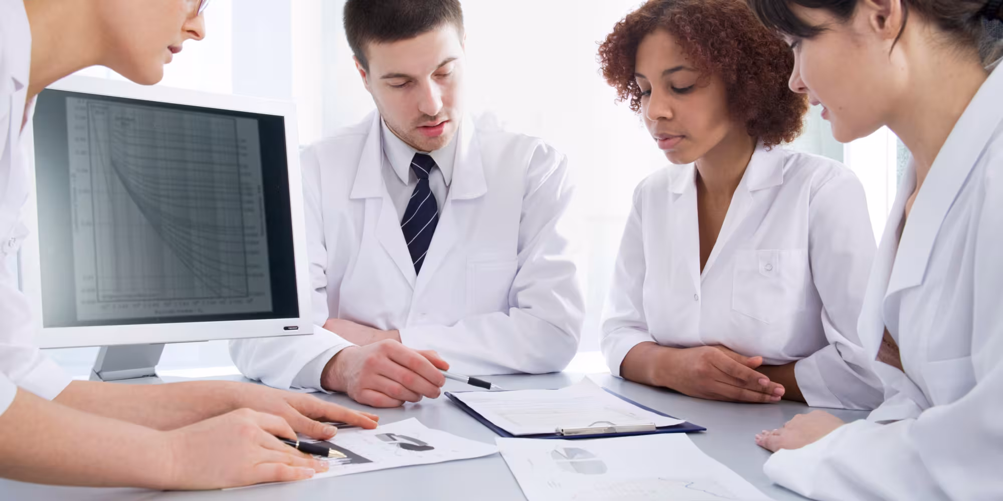 Four young doctors discussing a diagnosis Website Header 