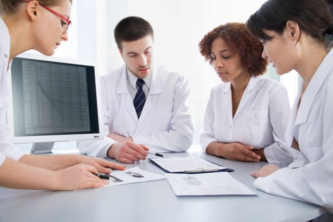 Four young doctors discussing a diagnosis